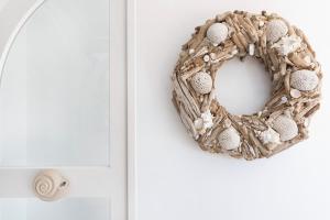 a wreath on a door next to a white cabinet at Stelia Mare Boutique Hotel in Naousa