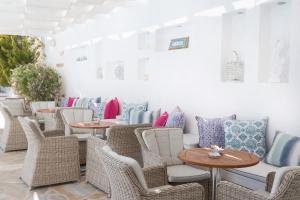 a row of tables and chairs with pillows at Stelia Mare Boutique Hotel in Naousa