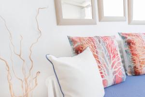 a room with two pillows and a wall with paintings at Stelia Mare Boutique Hotel in Naousa