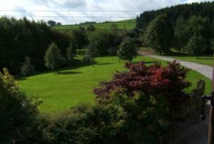 a green field with trees and a road at Loadbrook Cottages in Sheffield