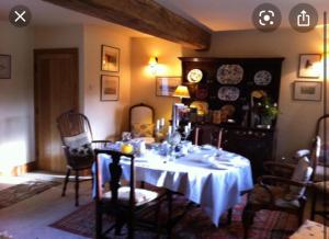 ein Esszimmer mit einem Tisch und einem weißen Tischtuch in der Unterkunft Loadbrook Cottages in Sheffield