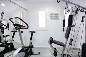 a gym with two exercise bikes in a room at Stelia Mare Boutique Hotel in Naousa