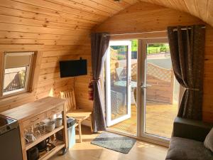 a log cabin with a sliding door to a deck at Conifer Cabins in Fort William