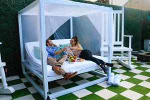 un homme et une femme assis sur un lit dans un kiosque dans l'établissement 4 BR - Sleeps 8! Best location next to Bourbon Street!, à La Nouvelle-Orléans