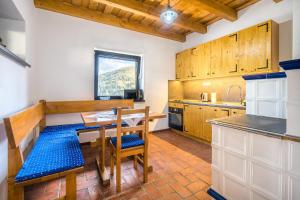 a kitchen with a wooden table and a table and chairs at Ubytovanie pod gaštanom in Hodruša