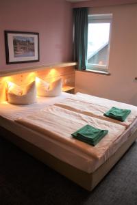 um quarto com uma cama grande e 2 toalhas verdes em Ferienstudio em Kurort Oberwiesenthal