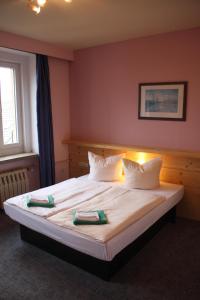 1 dormitorio con 1 cama con sábanas y almohadas blancas en Ferienstudio en Kurort Oberwiesenthal