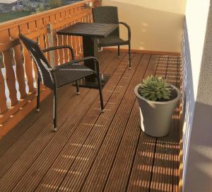 a balcony with two chairs and a table and a potted plant at Ferienwohnung Hofmeister in Heilbad Heiligenstadt
