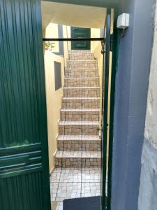 una escalera que conduce a un edificio con una puerta verde en Casa Zona Velha - Caetano, en Funchal