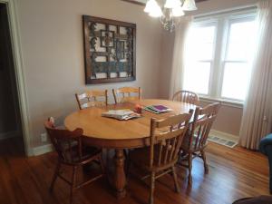 a dining room table with chairs and a wooden table at Covered By Faith Rentals -Storybook Home in Rochester