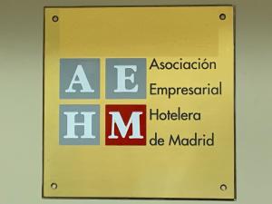 ein gelbes Schild mit den Worten „association governmentalractical hudalore de madici“ in der Unterkunft Hostal Juan XXIII in San Sebastián de los Reyes