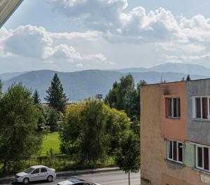 a car parked on a street with mountains in the background at Hostel Ghimbav Airport in Ghimbav