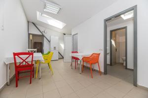 a room with a table and colorful chairs at Hostel Ghimbav Airport in Ghimbav