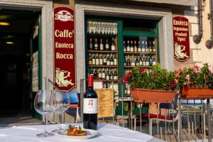 una mesa con una botella de vino y un plato de comida en Appartamenti Rocca - CAV La Casa di Rosa, en Monforte dʼAlba