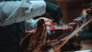 a person cutting a piece of meat with a knife at Zenit Convento San Martin in Donostia-San Sebastián