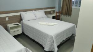 a bed with a white tray on top of it at RUBBO HOTEL in São Valentim