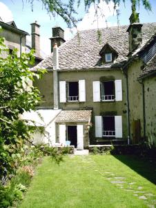 una casa vieja con un patio delante en Chambre d'Hôtes La Maison de Barrouze, en Salers