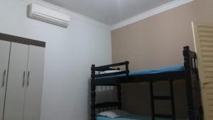 Pokój z 2 łóżkami piętrowymi i drzwiami w obiekcie Nosso Lar casa inteira, completa e independente w mieście Barra do Garças