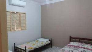 a bedroom with two beds and a window at Nosso Lar casa inteira, completa e independente in Barra do Garças +6 photos