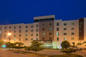 a large building with a parking lot in front of it at Holiday Inn Express Ciudad Del Carmen by IHG in Ciudad del Carmen