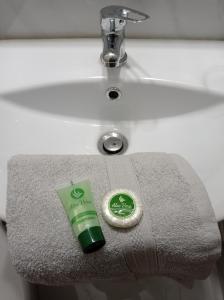 a green tube of toothpaste sitting on a sink at Central Home in Tríkala +19 photos