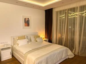 a white bedroom with a bed and a window at Pirin Golf Studio Apartment in Razlog +27 photos