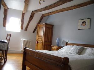 1 dormitorio con 1 cama y armario de madera en Chambre d'Hôtes La Maison de Barrouze, en Salers