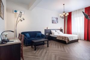 a bedroom with a bed and a chair and a table at Apart hotel Oblaka in Biysk