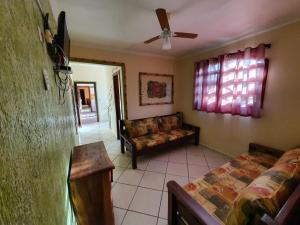 a living room with a couch and a ceiling fan at Peruíbe Suíte Flat Hotel in Peruíbe
