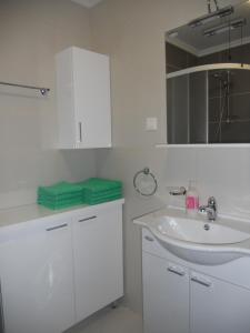 a white bathroom with a sink and a mirror at 1 BR Apt - North Coast Croatia in Crikvenica