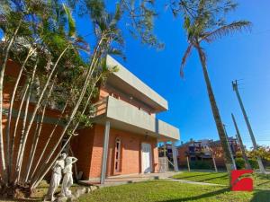a house with two statues in front of it at Casa beira mar Torres in Torres