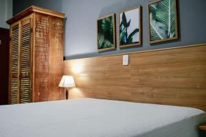 1 dormitorio con 1 cama y 3 cuadros en la pared en Pousada Solmaior, en Conservatória