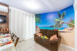 伊塔佩马FLAT Promoção Mensal的带沙发和海滩壁画的客厅
