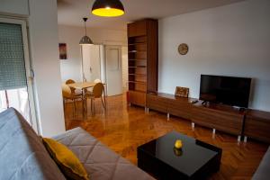 een woonkamer met een bank, een tv en een tafel bij Gevgelija Downtown Apartment in Gevgelija