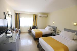 a hotel room with two beds and a television at Nuweiba Club Resort in Nuweiba