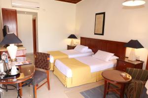 a hotel room with two beds and a table and chairs at Nuweiba Club Resort in Nuweiba