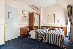 a hotel room with a bed and a dresser at Hotel Flora in Milan
