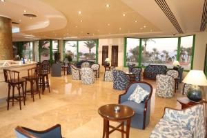 a lobby with chairs and tables and a bar at Nuweiba Club Resort in Nuweiba