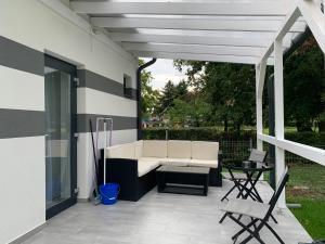 a patio with a white couch and a table at Zenit Apartman in Bükfürdő