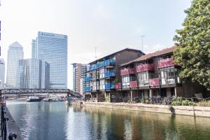 a river in a city with buildings and a bridge at Larger Groups Apartment close to Excel CanaryWharf 02 with Parking in London