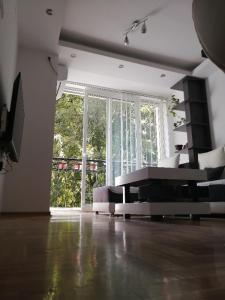 un soggiorno con divano e una grande finestra di Ana Apartment a Novi Sad
