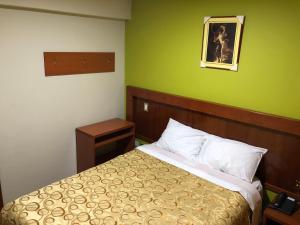 a bedroom with a bed and a green wall at Sumaq Hotel Tacna in Tacna