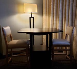 a dining room table with two chairs and a lamp at Coast Kamloops Hotel & Conference Centre in Kamloops