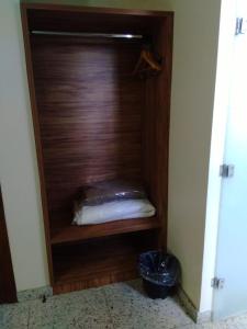 a room with a wooden closet with a pillow at TOPÁZIO IMPERIAL HOTEL in Itaúna