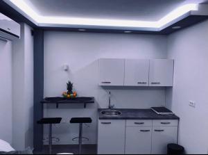 a kitchen with white cabinets and bar stools at Jacuzzi Apartment Code 96 in Zagreb +11 photos