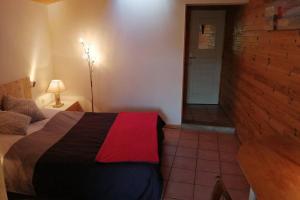 een slaapkamer met een bed en een bakstenen muur bij Studio 22 m2, terrasse vue montagne, dans propriété face au Lac du Salagou in Liausson
