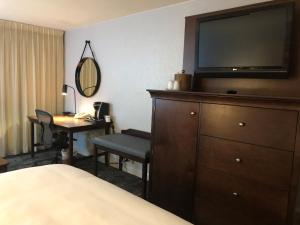 a hotel room with a bed and a dresser with a television at Crowne Plaza Chicago-Northbrook, an IHG Hotel in Northbrook