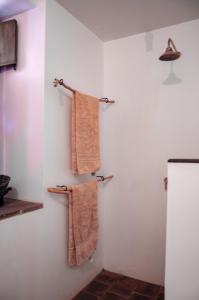 bagno con asciugamani appesi a una parete di Nacuma Garden Hostel - Casa Nacuma a Barichara Altre 37 foto