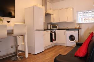 a kitchen with a white refrigerator and a washing machine at Modern Newgate Apartments - Convenient Location, Close to All Local Amenities in Stoke on Trent