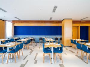 a dining room with tables and blue chairs at Holiday Inn Express Litang by IHG in Lithang
